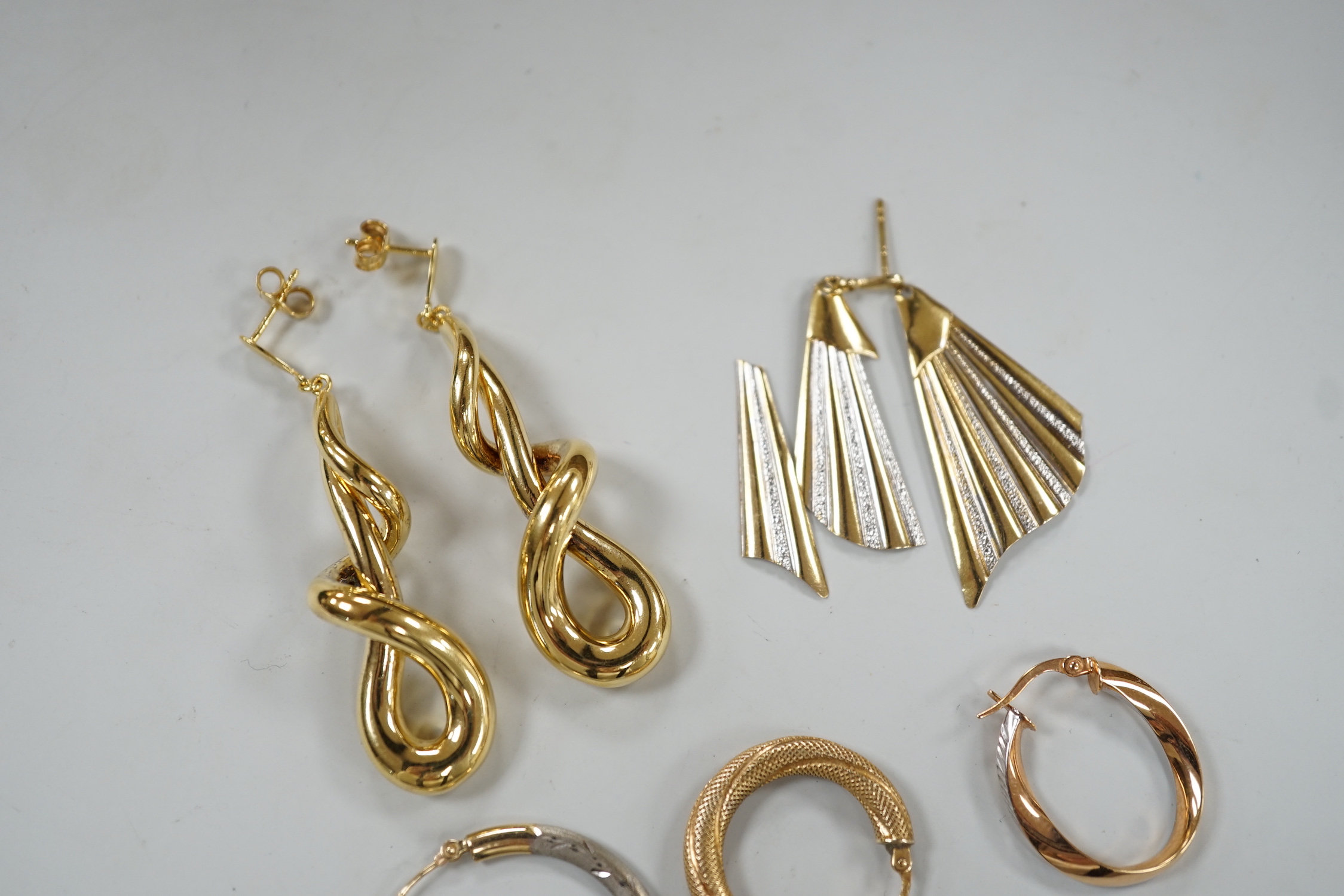 A modern pair of 9ct gold scrolling drop earrings, 47mm, three odd 9ct gold earrings and three 9ct earring fragments, 13.4 grams.